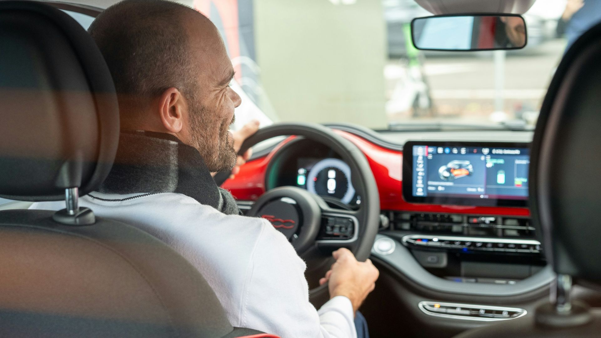 A man driving a car with a steering wheel