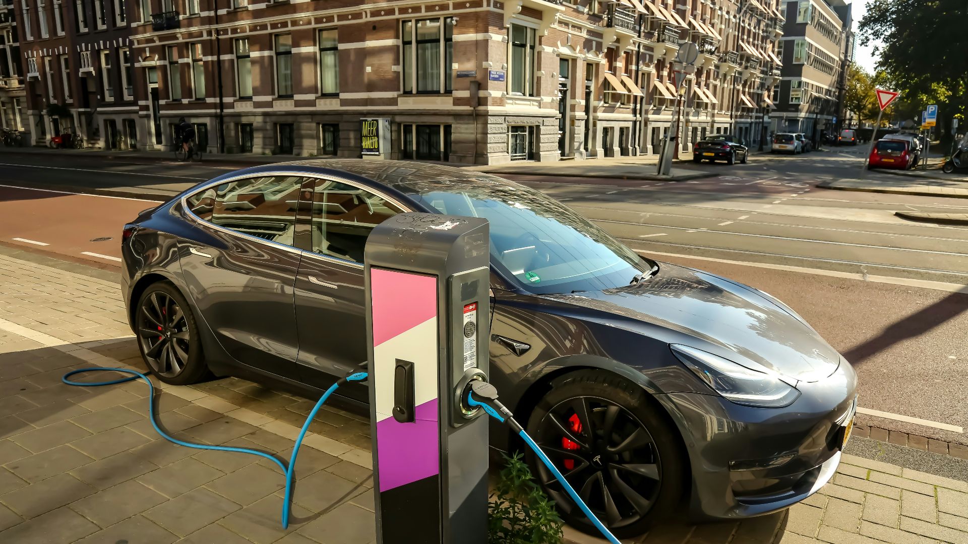 a car plugged into a charging station on a city street