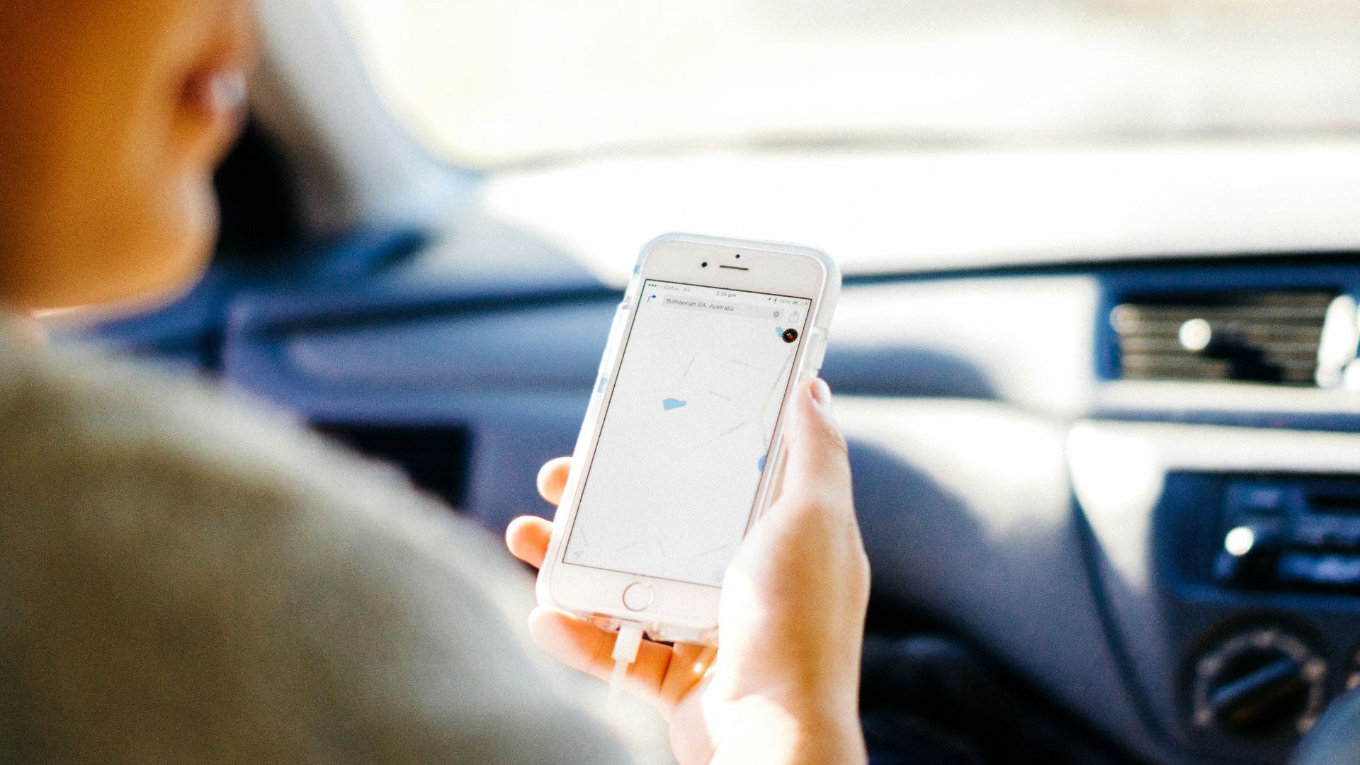 a woman holding a cell phone in a car