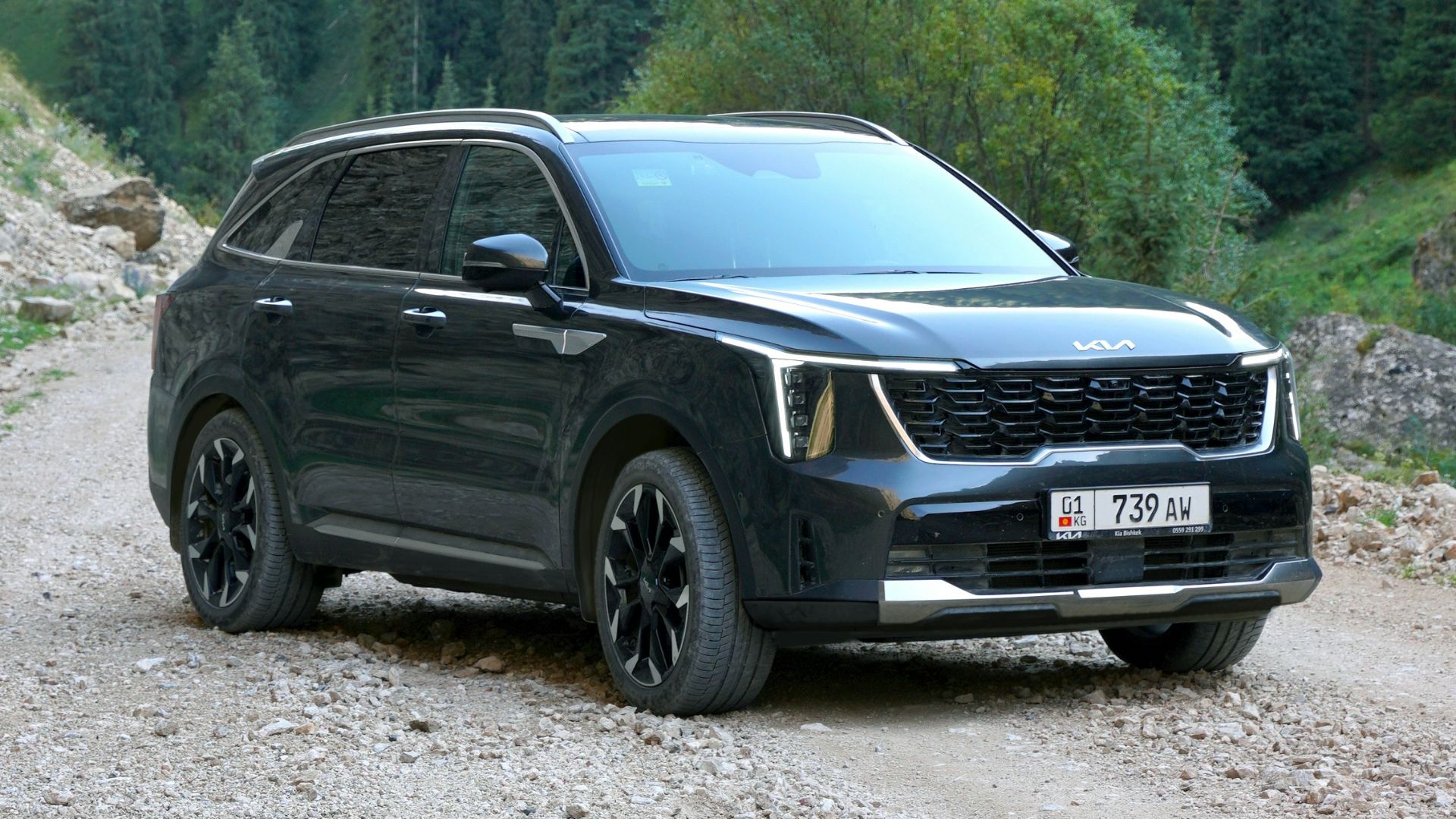 A black suv is parked on a gravel road
