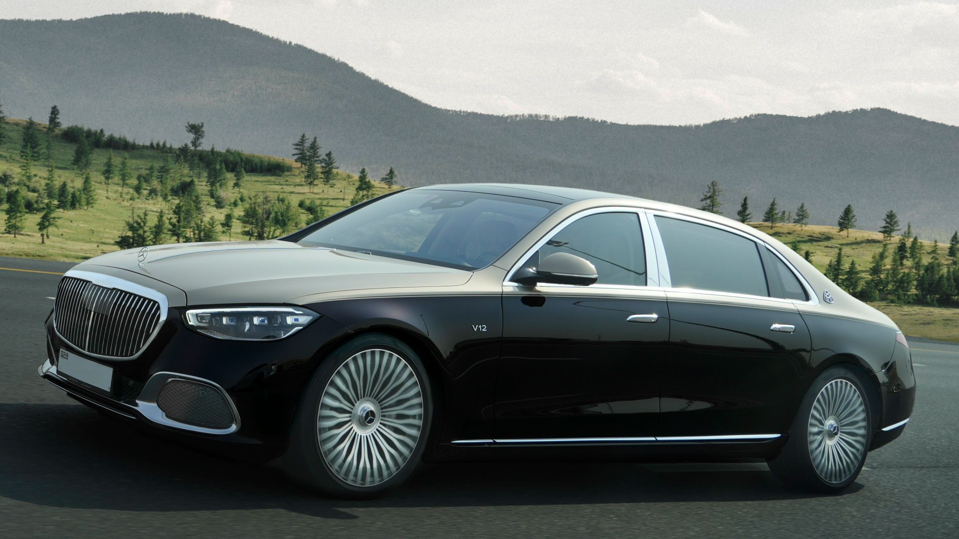 a black car driving down a road next to a forest