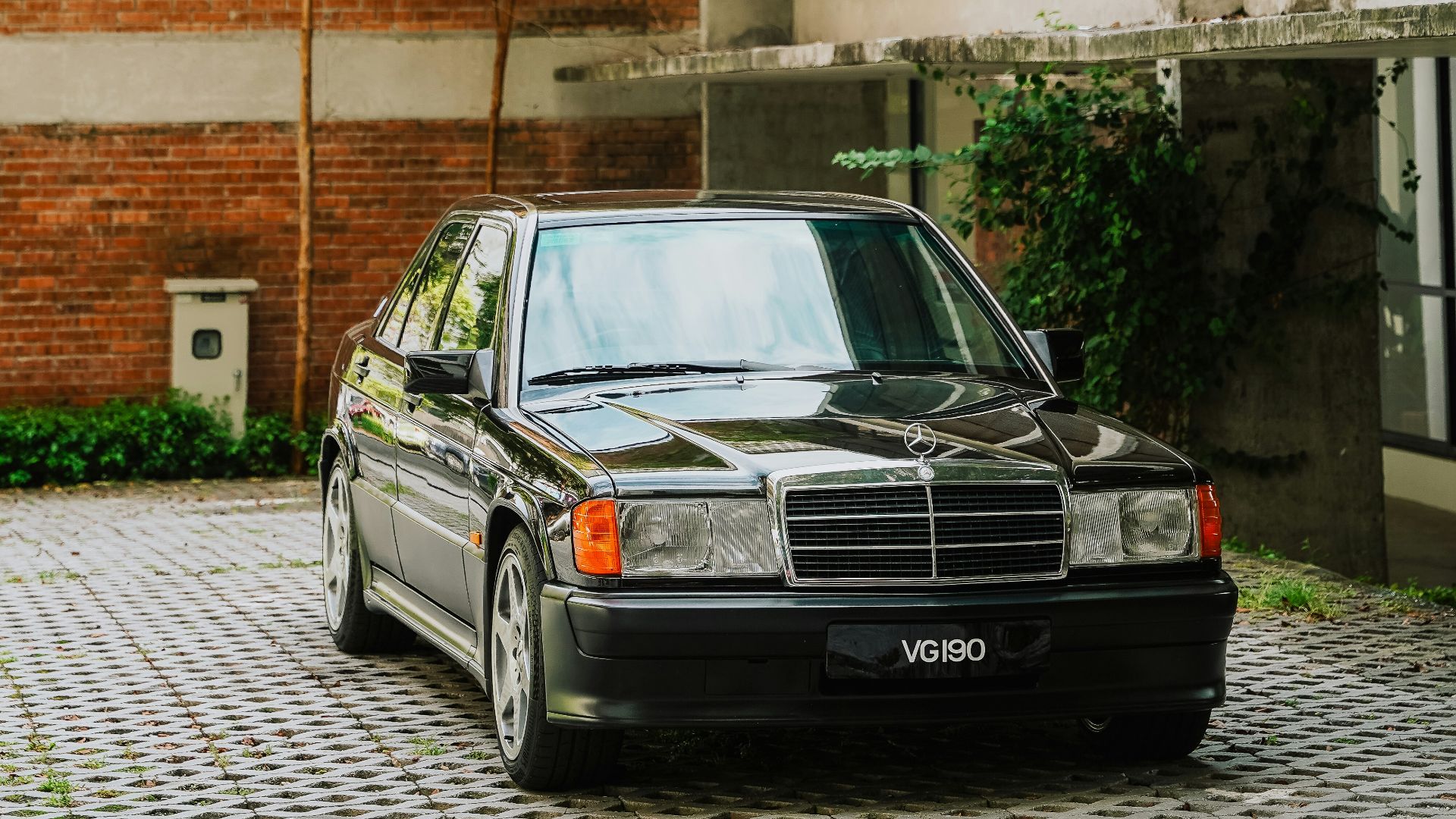 A black vintage mercedes-benz parked outside building.