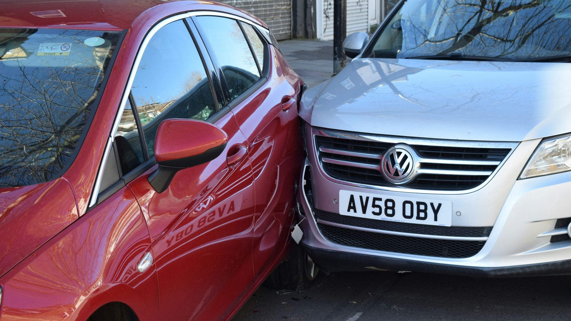two cars parked next to each other in a parking lot