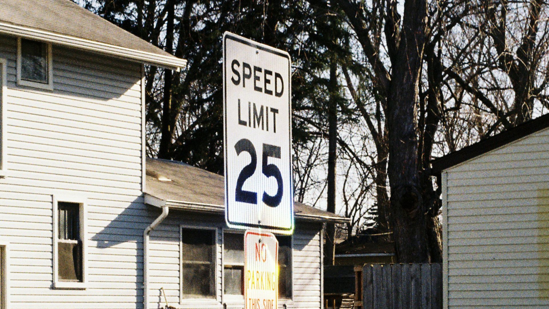 a speed limit sign in front of a house