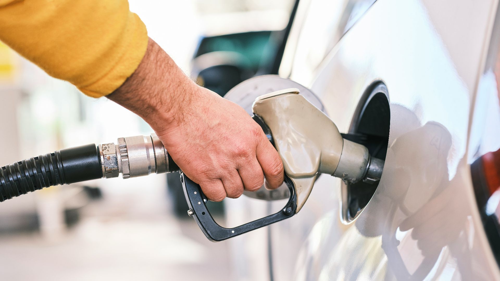 a man pumping gas into his car at a gas station