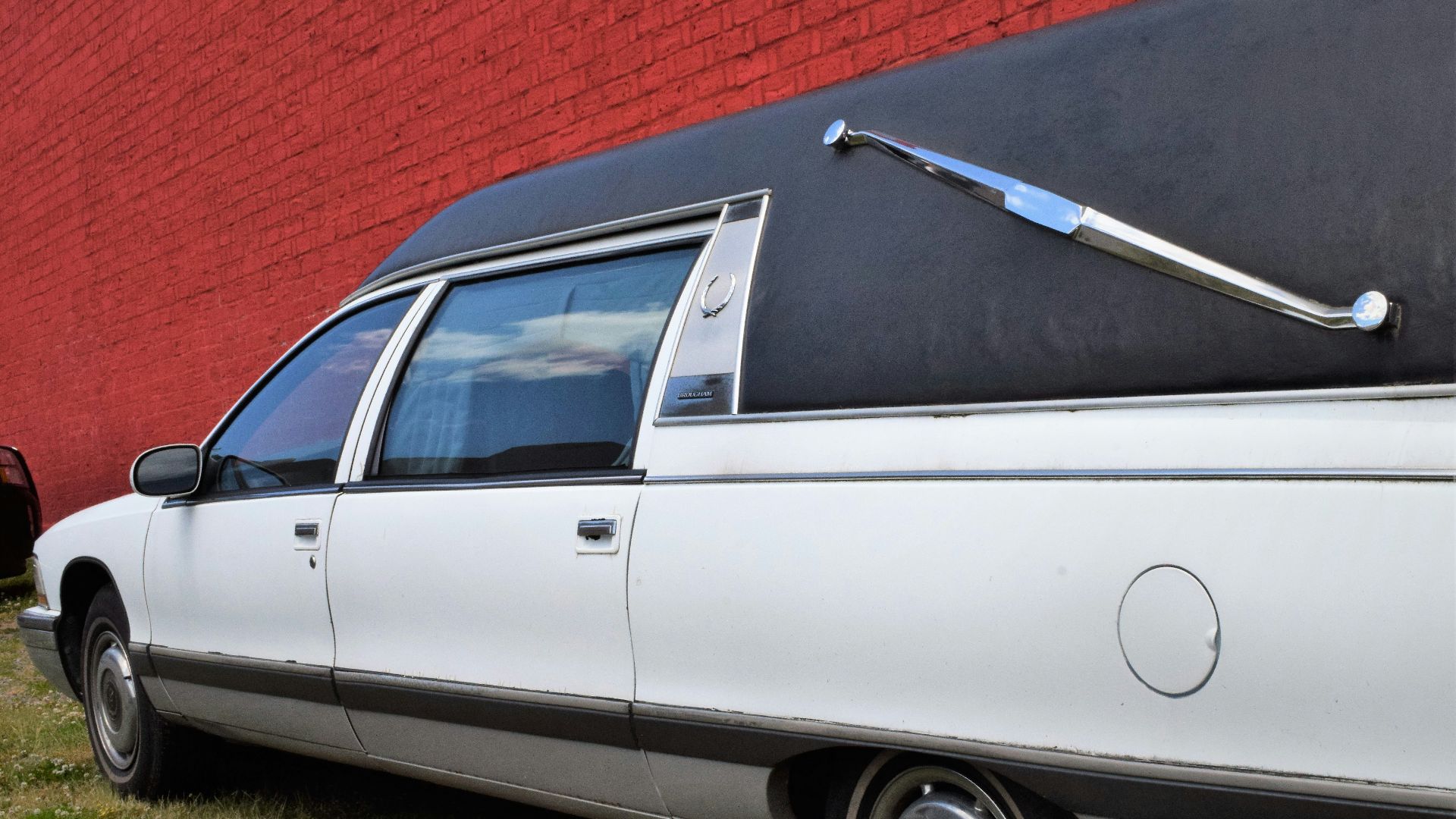a white car parked in front of a red wall