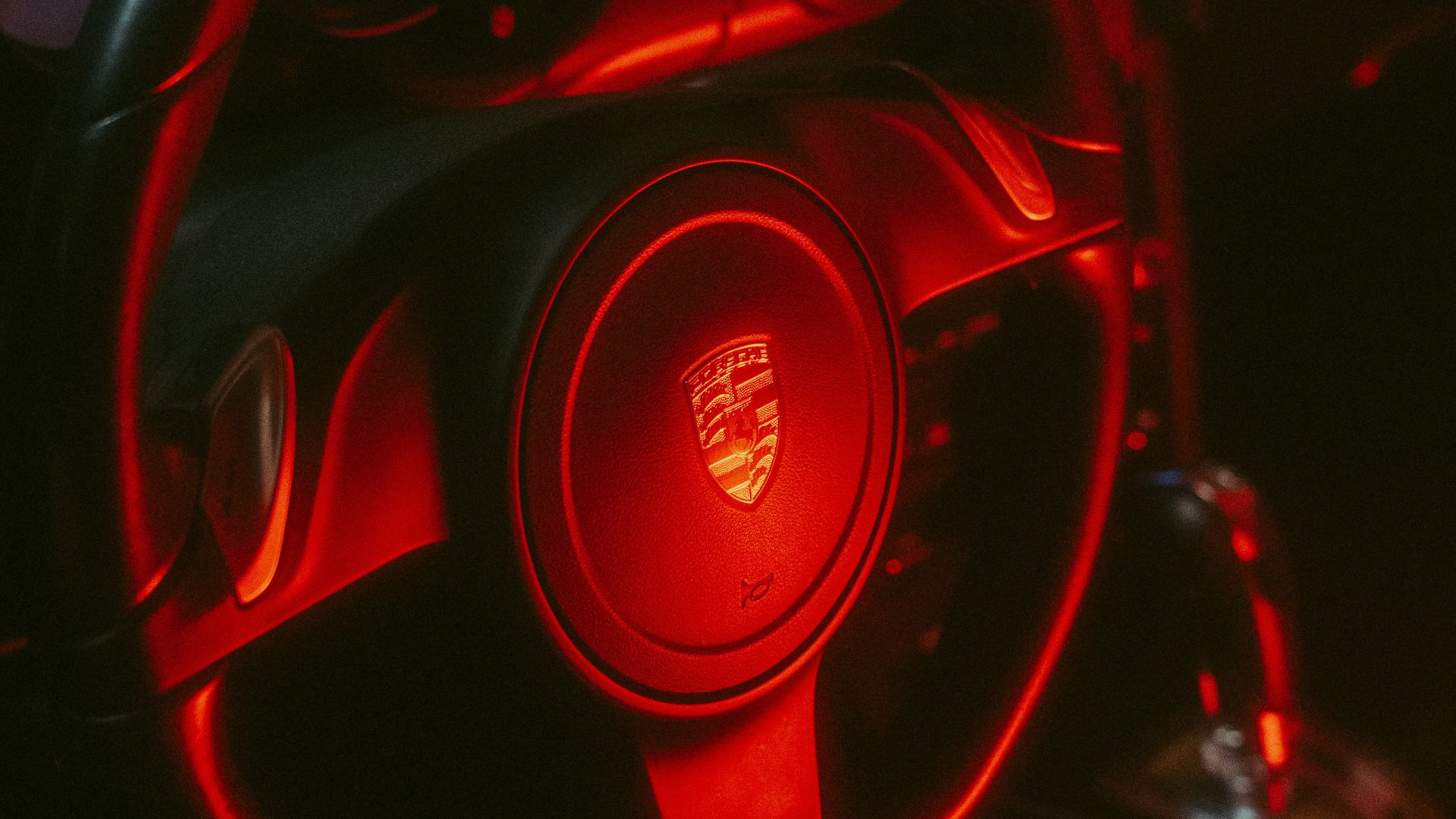 a close up of a steering wheel with a red light