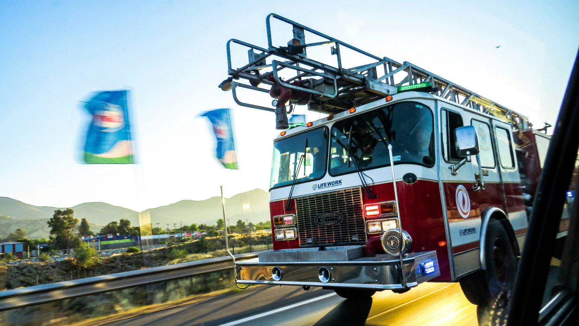 Fire truck driving on a highway at sunset