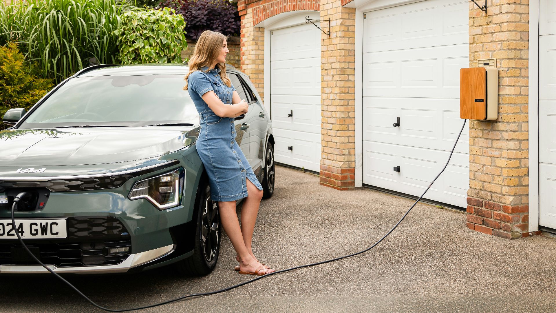 A woman washing a car in a driveway