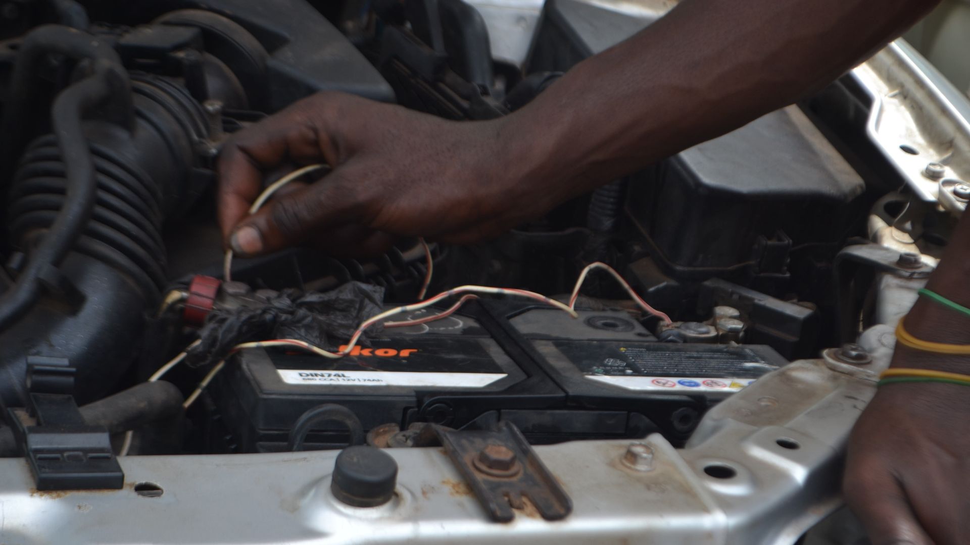 File:Mechanic working on a car battery.jpg