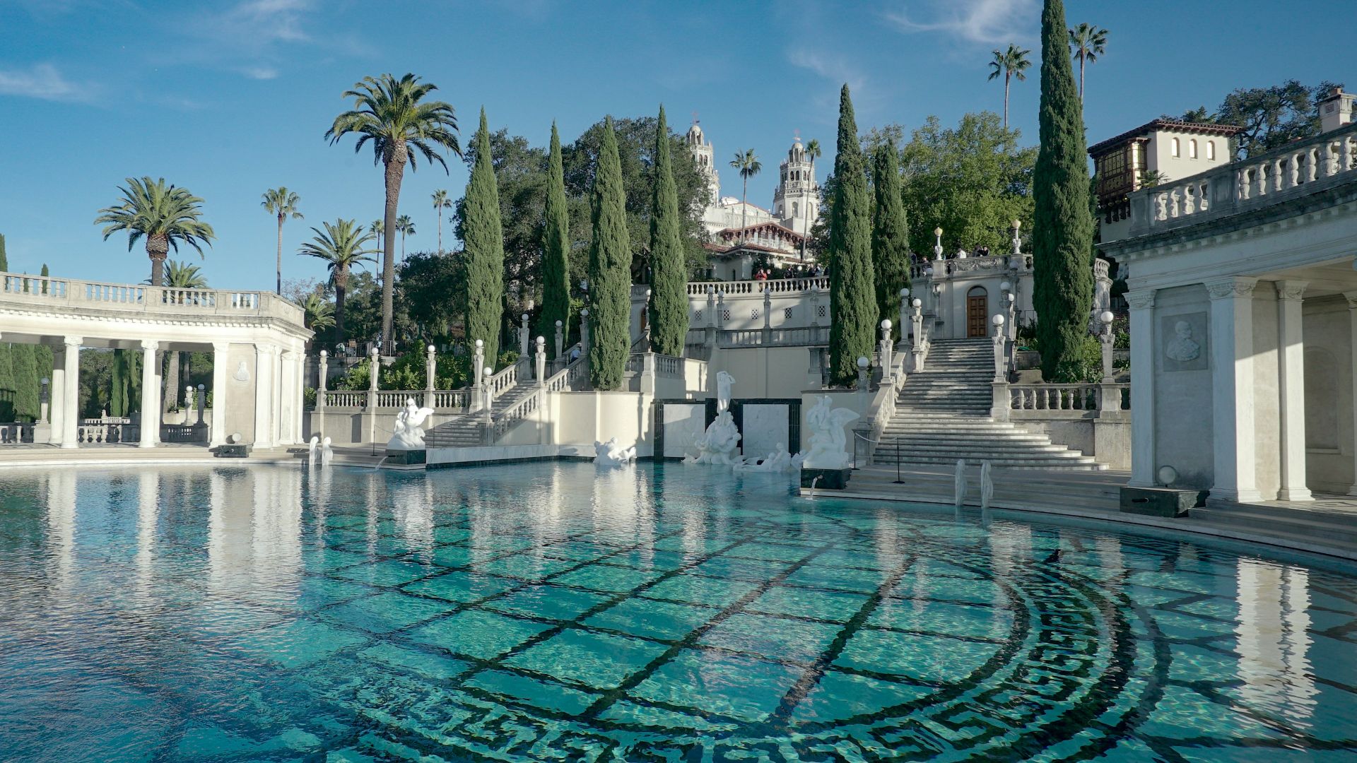 a pool with Hearst Castle in the background
