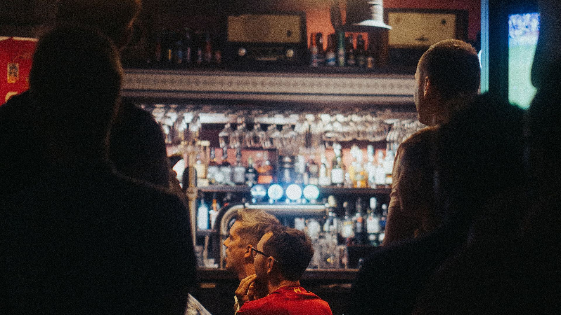 a group of people standing around a bar