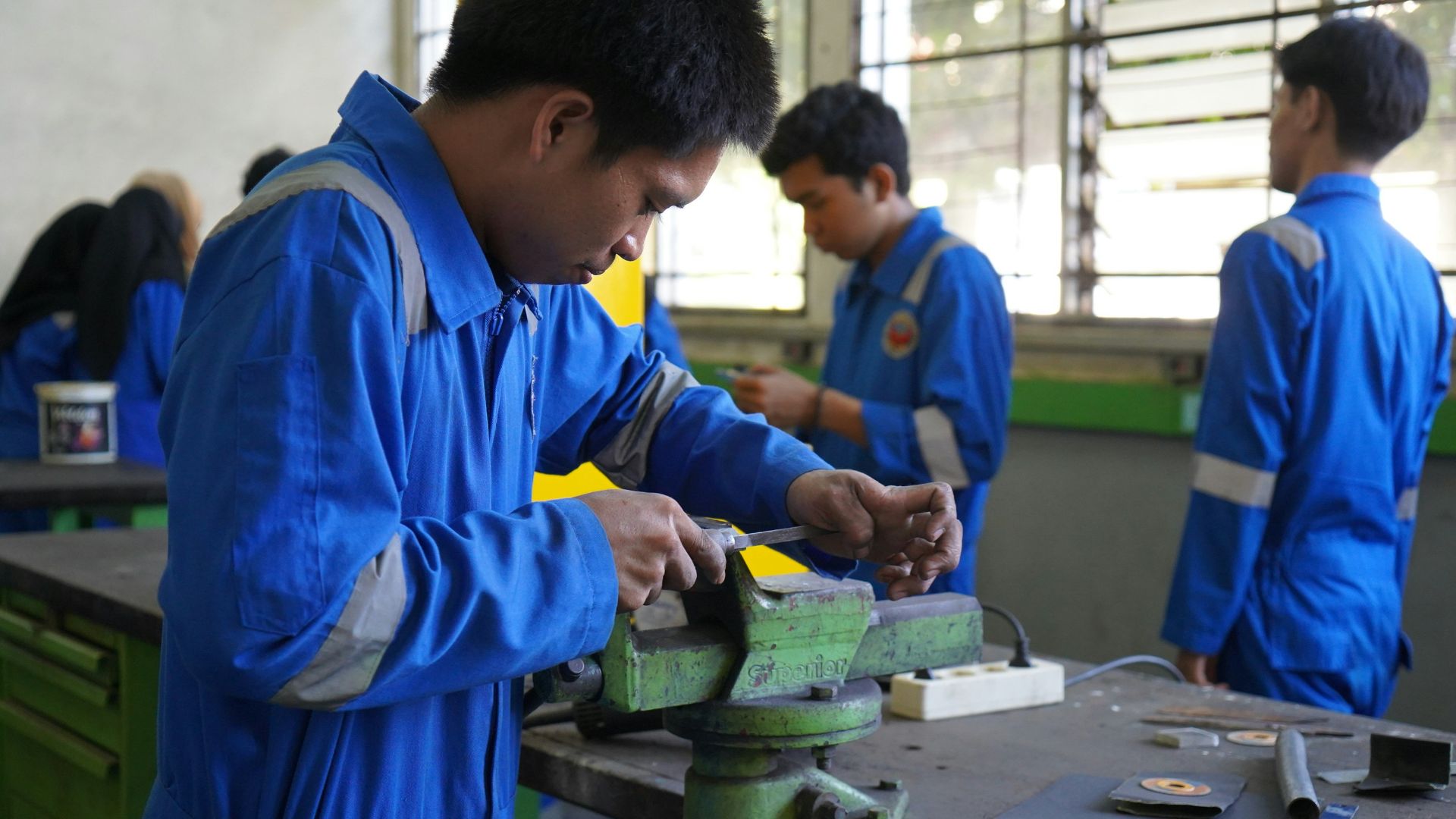 a group of men working on a piece of metal