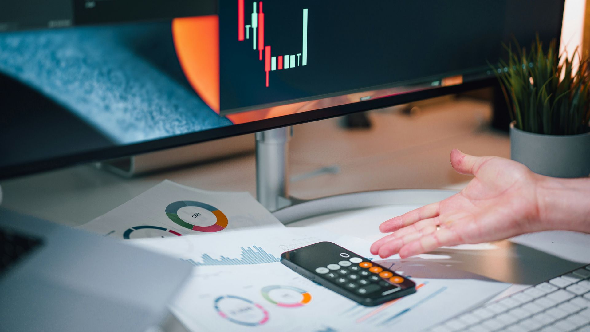 a person pointing at a calculator on a desk
