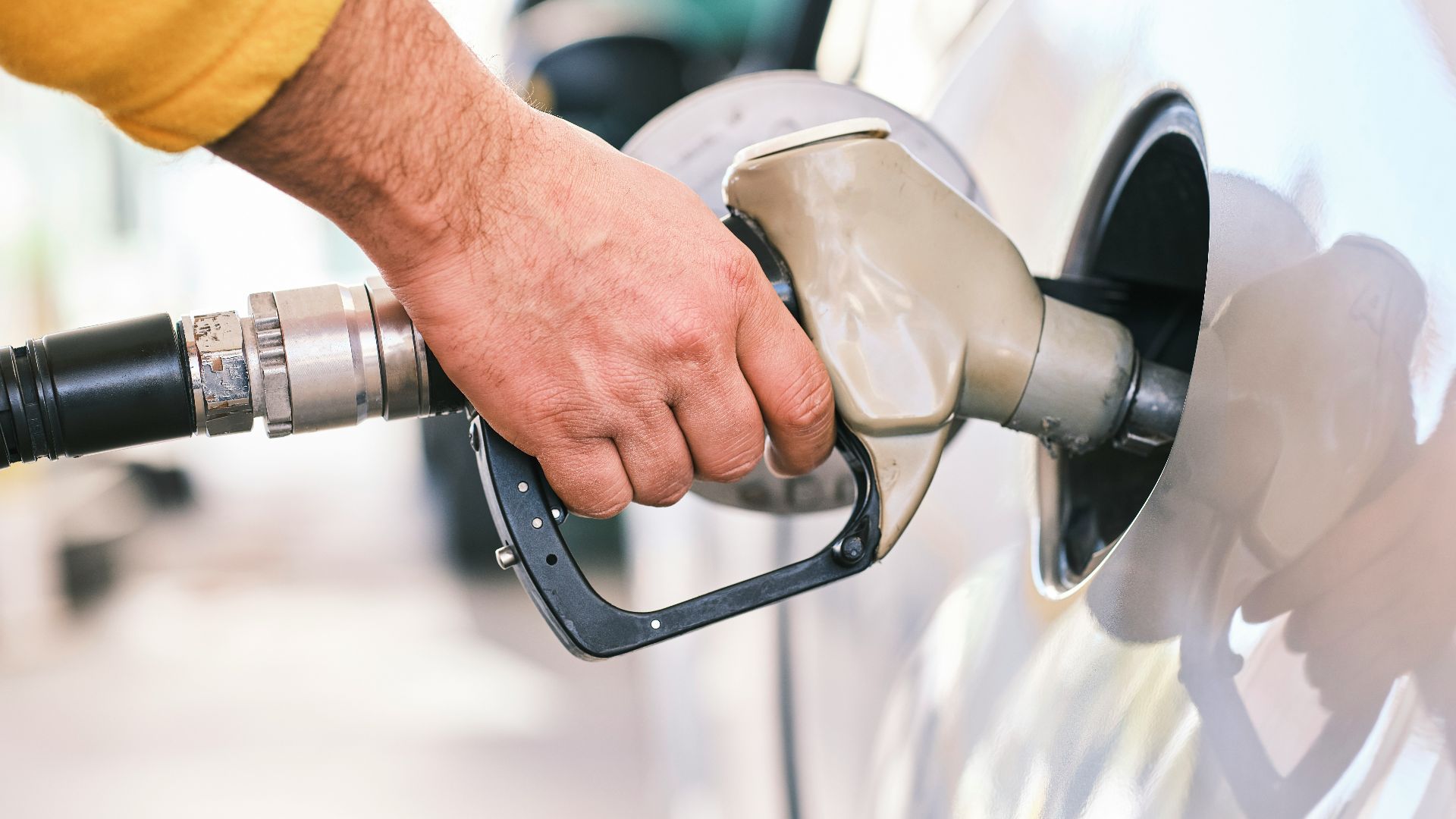 a man pumping gas into his car at a gas station