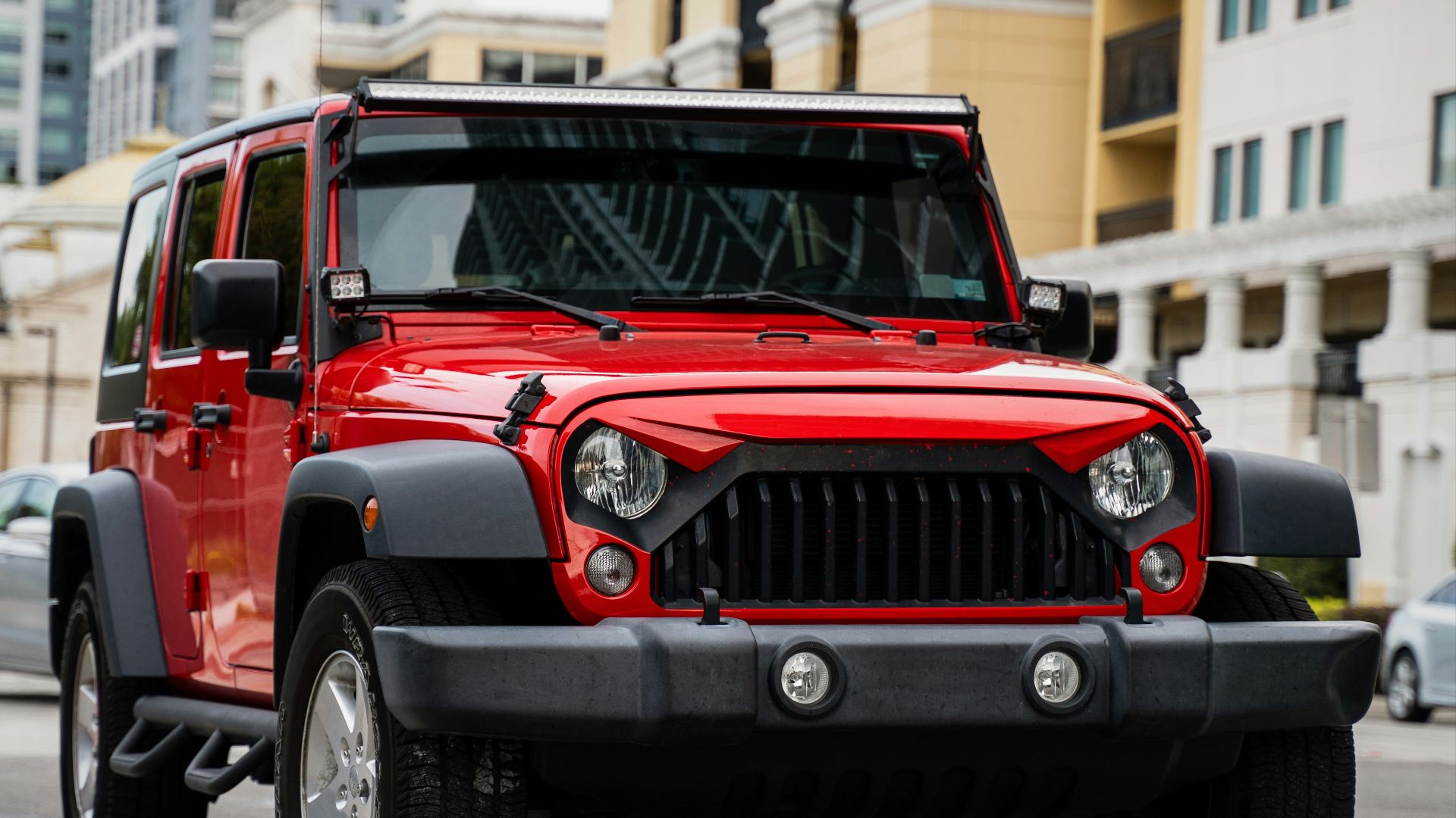 red jeep wrangler on road during daytime