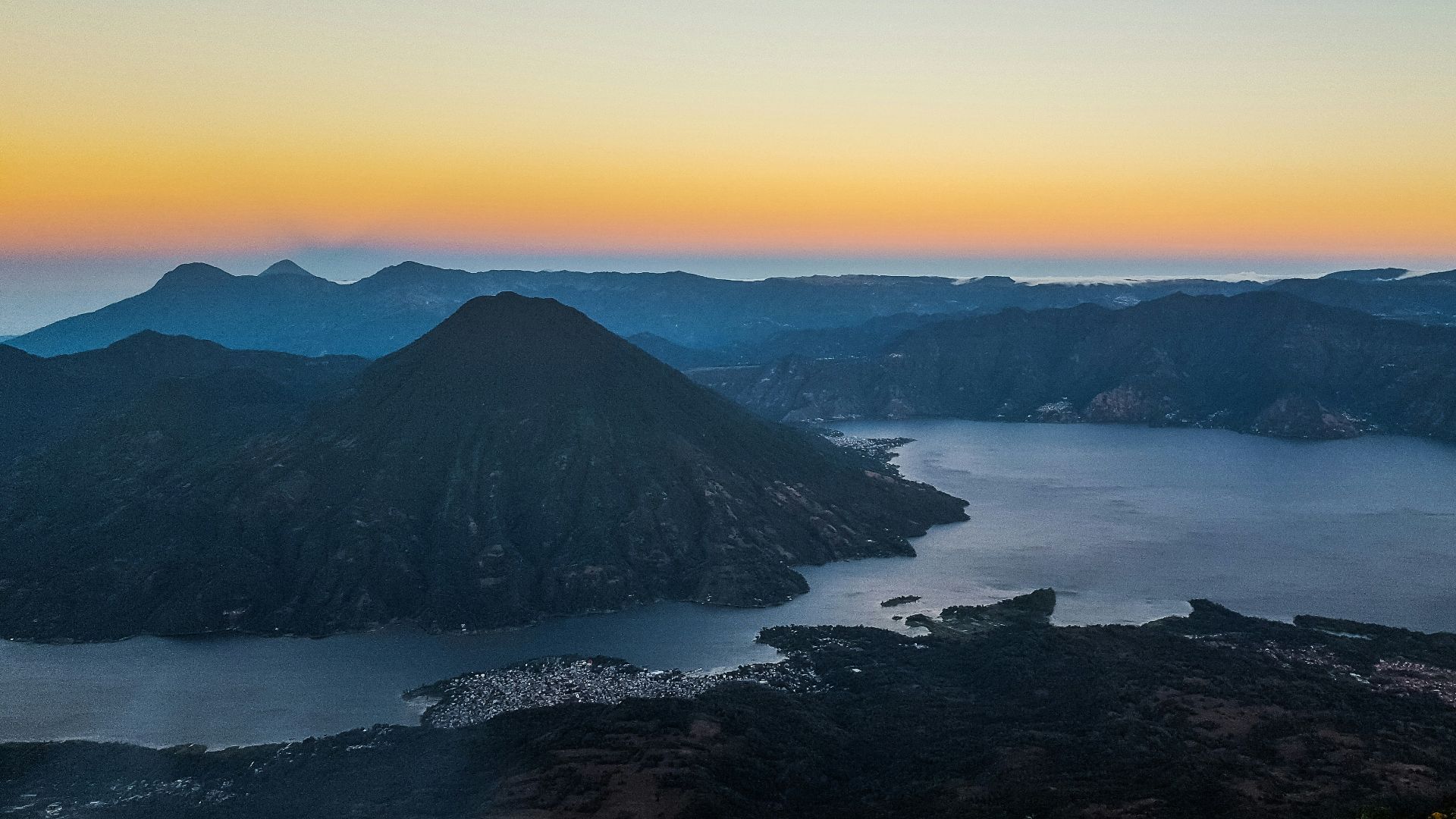 aerial photo of body of water beside mountain during daytime