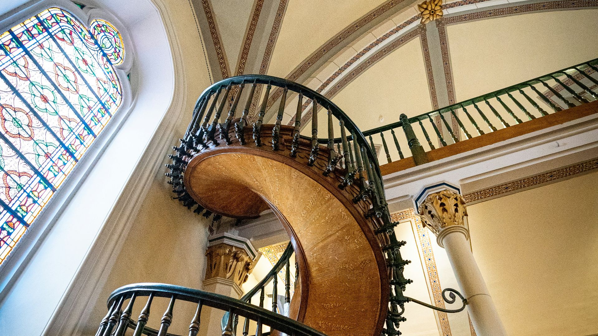 brown wooden spiral staircase with black metal railings