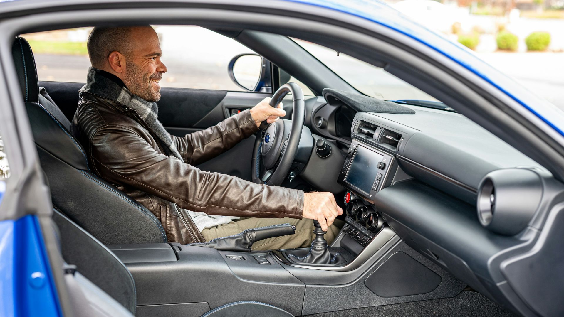A man sitting in a car with a steering wheel