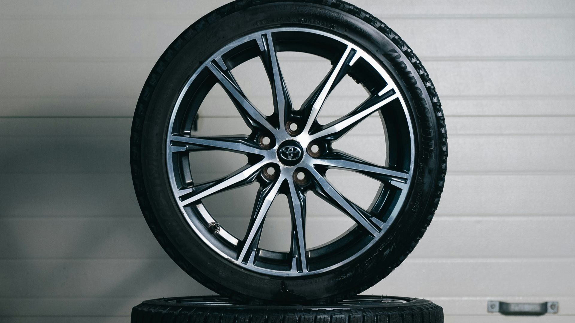 Stack of car tires with one alloy wheel on top