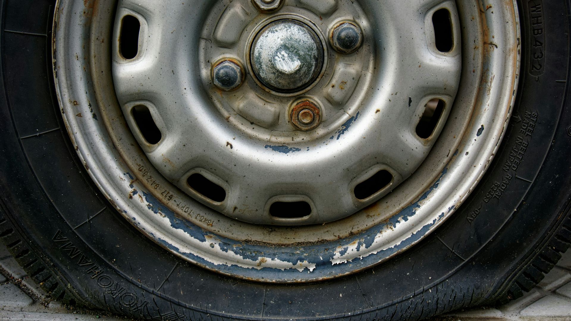 Close-up of a worn car tire and rim.
