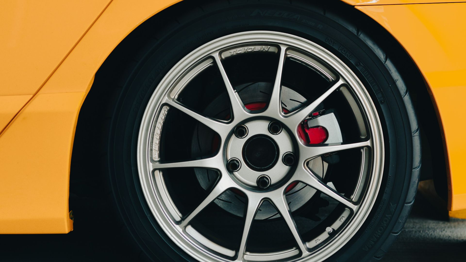 a close up of a wheel on a yellow sports car