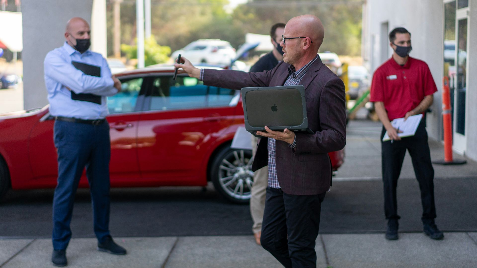 man in white dress shirt and black pants holding ipad