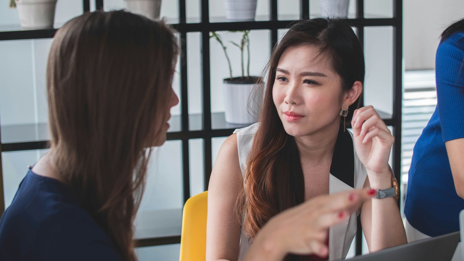 woman sitting on yellow armless chair near gray laptop computer