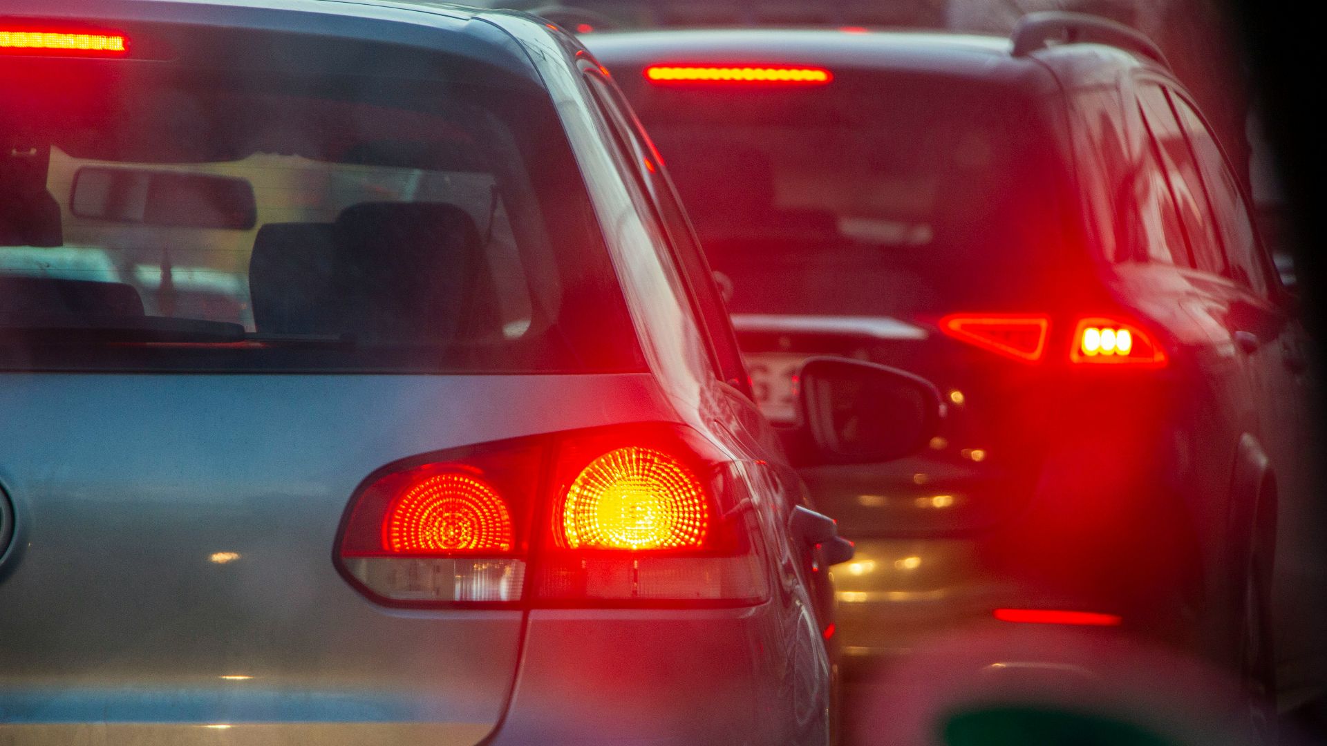 a group of cars driving down a street next to each other