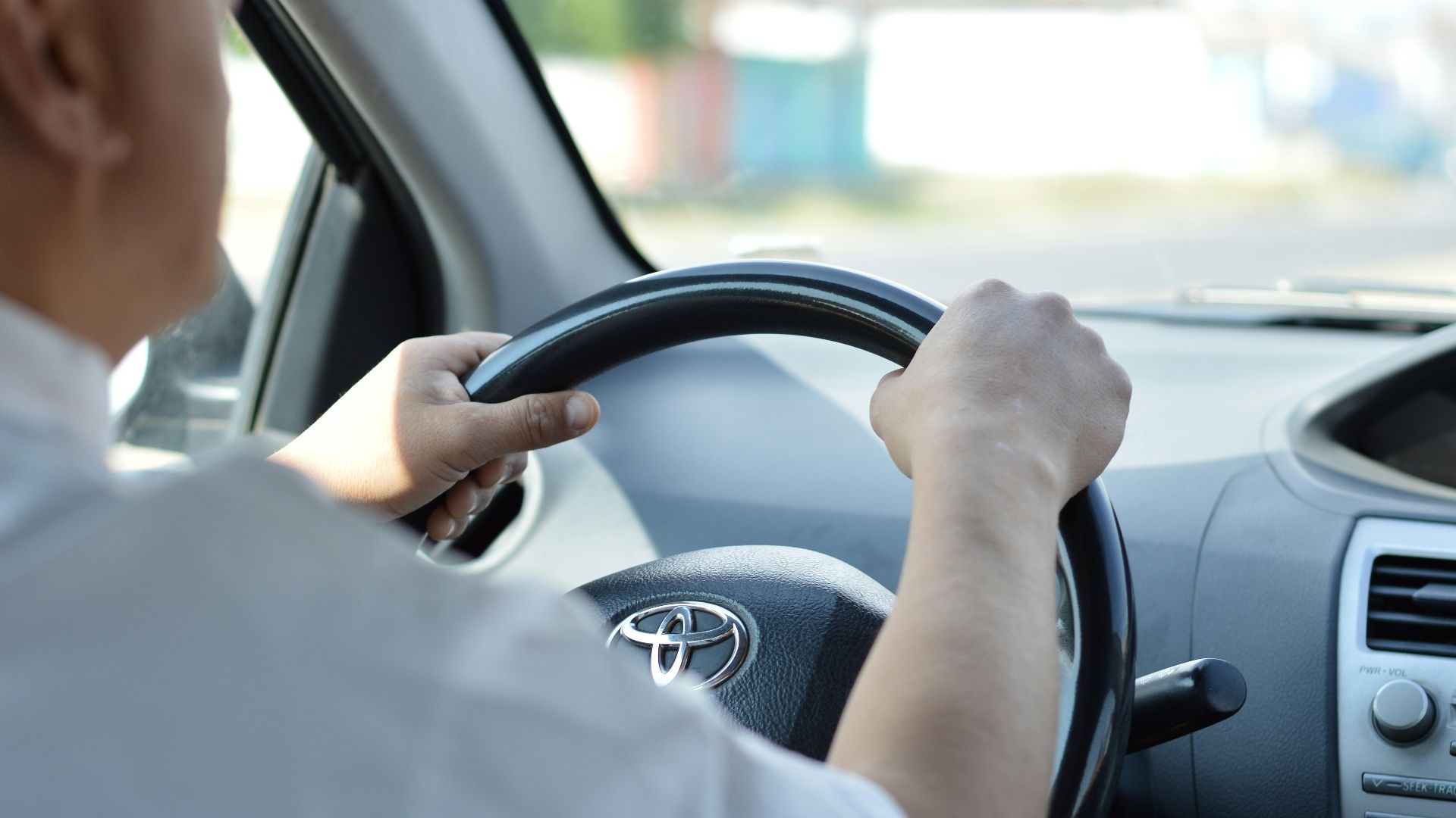 person in white long sleeve shirt driving car
