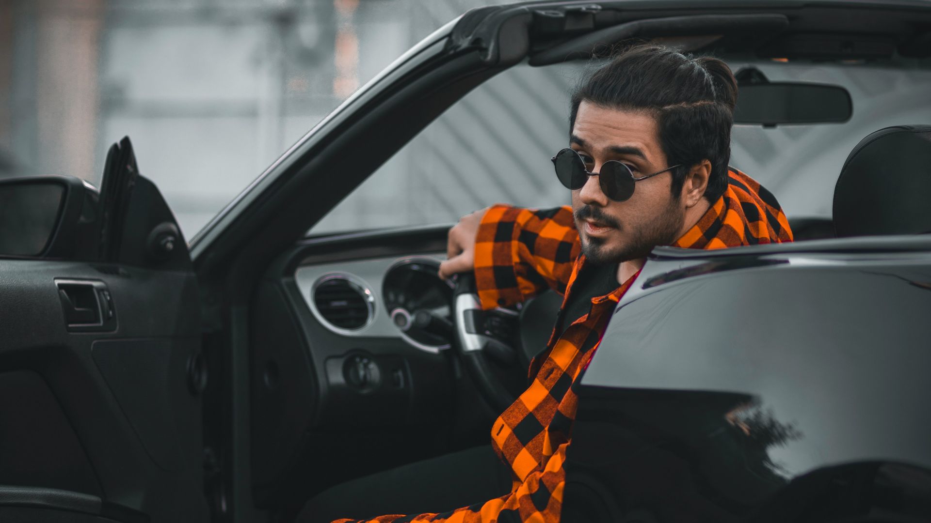 a man sitting in the driver's seat of a car