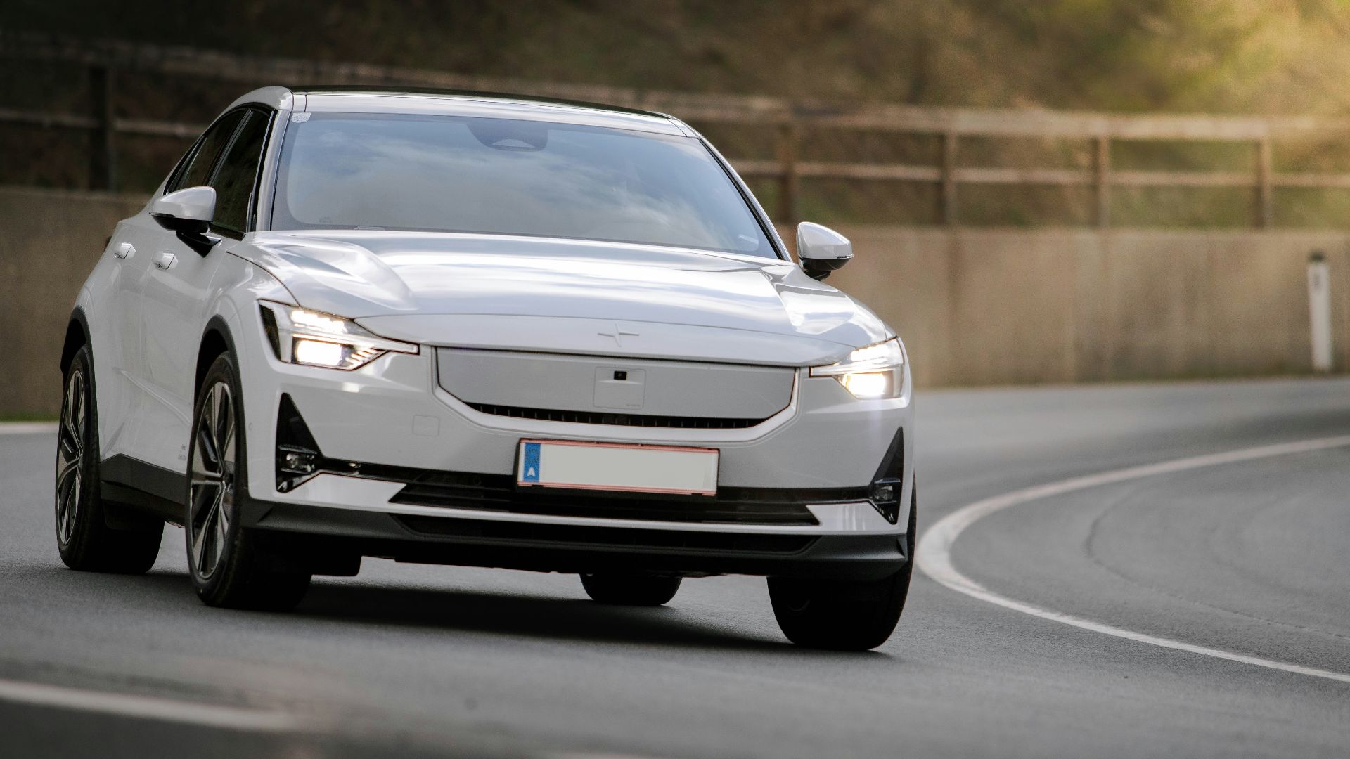 a white car driving down a curvy road