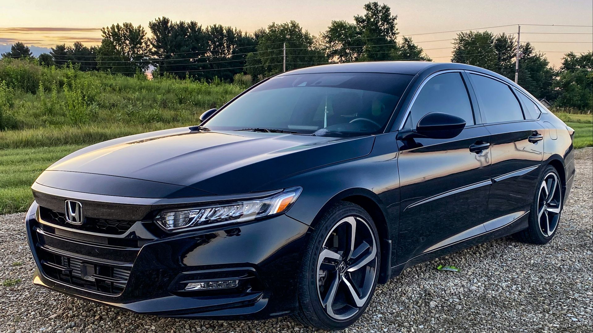 a black car parked on a gravel road