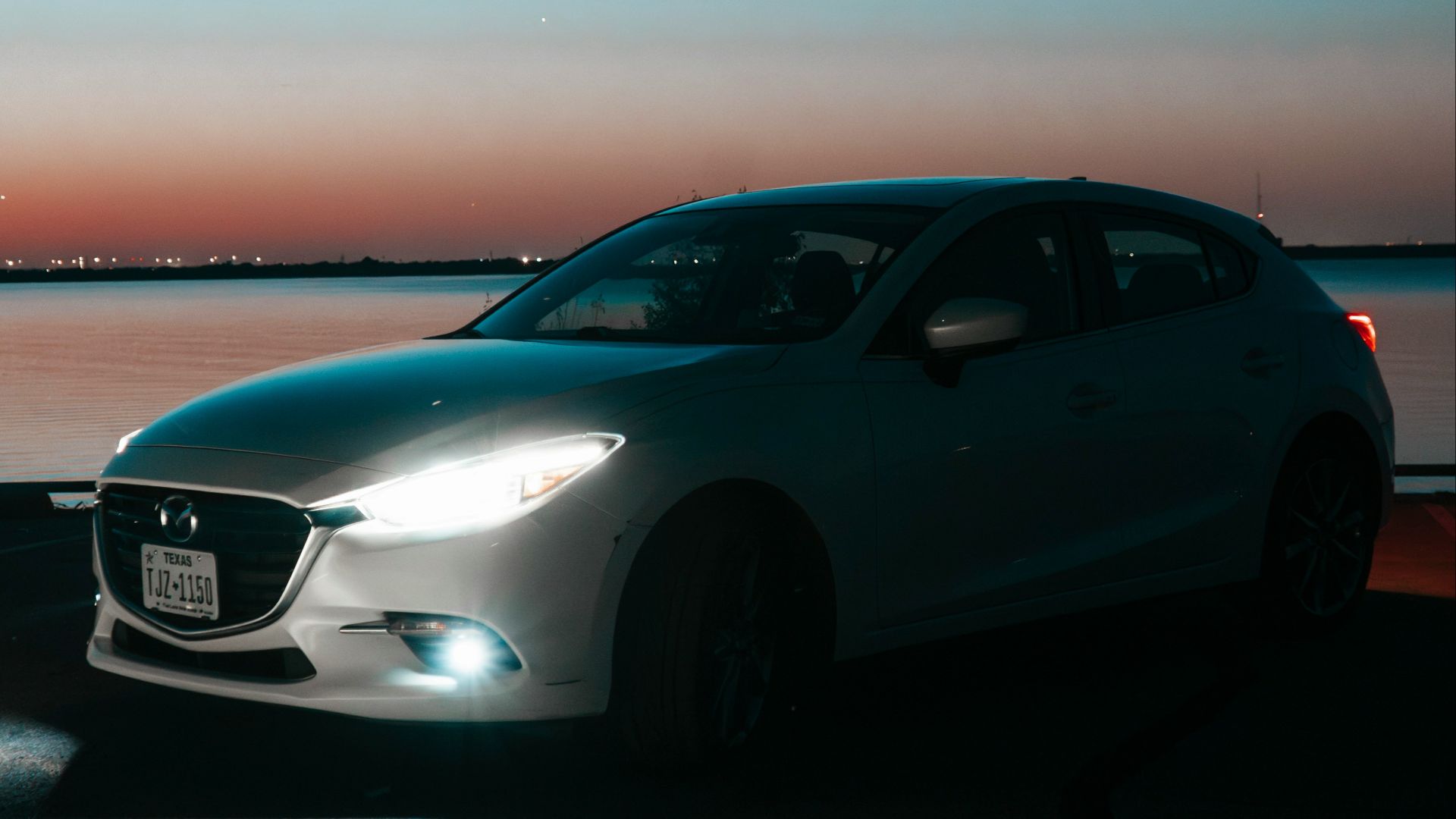 A car parked on the side of a road near a body of water