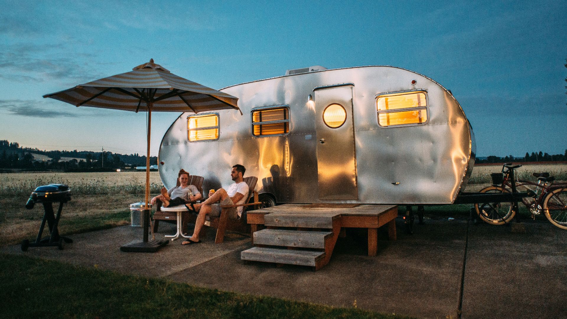 man and woman sitting in front of RV trailer