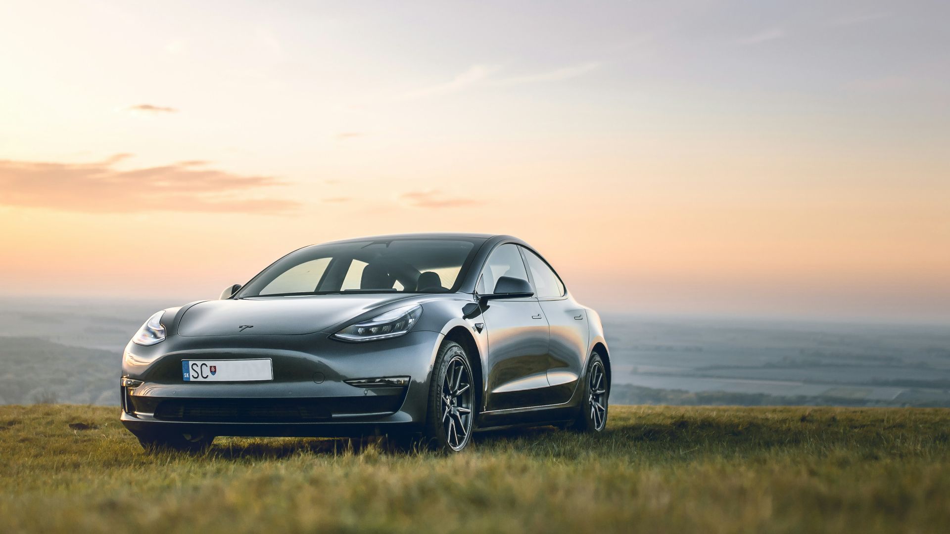 black sedan parked on grass field