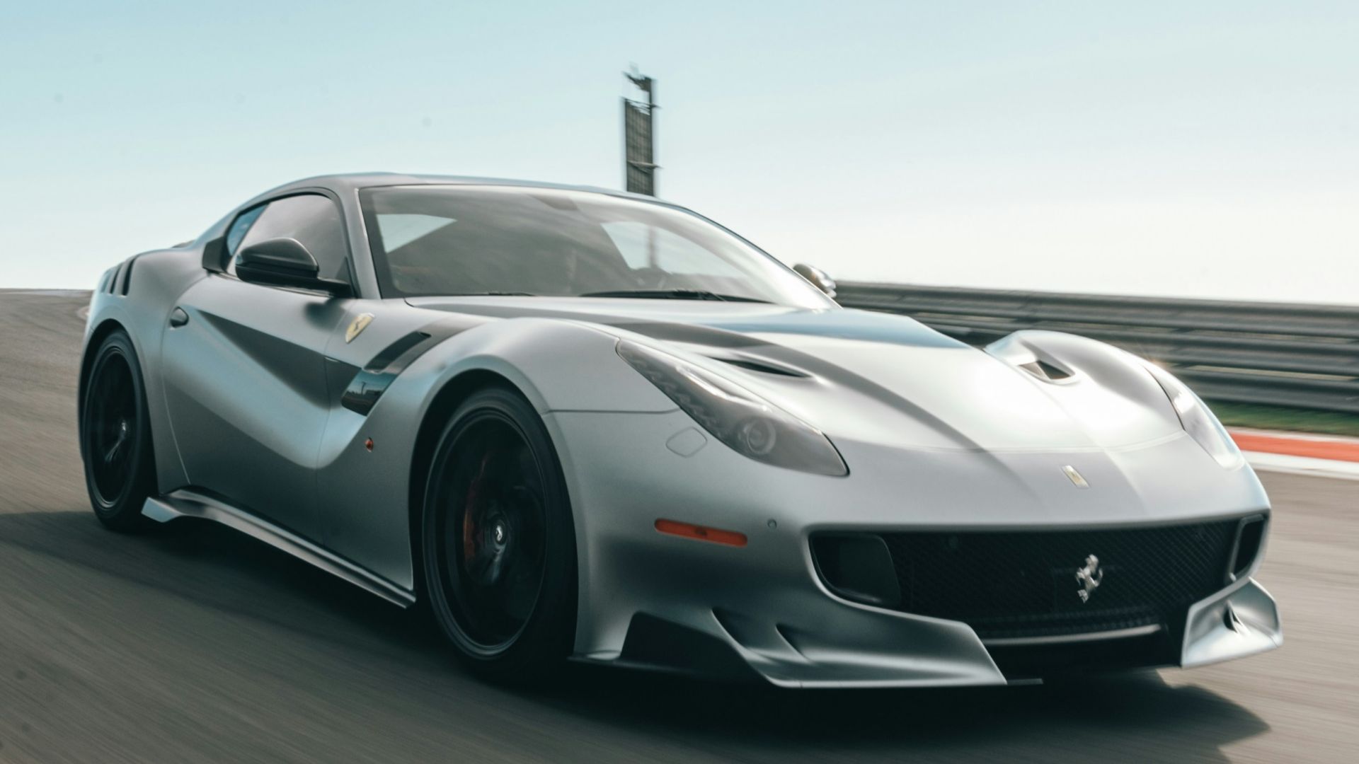silver coupe on road under white clouds