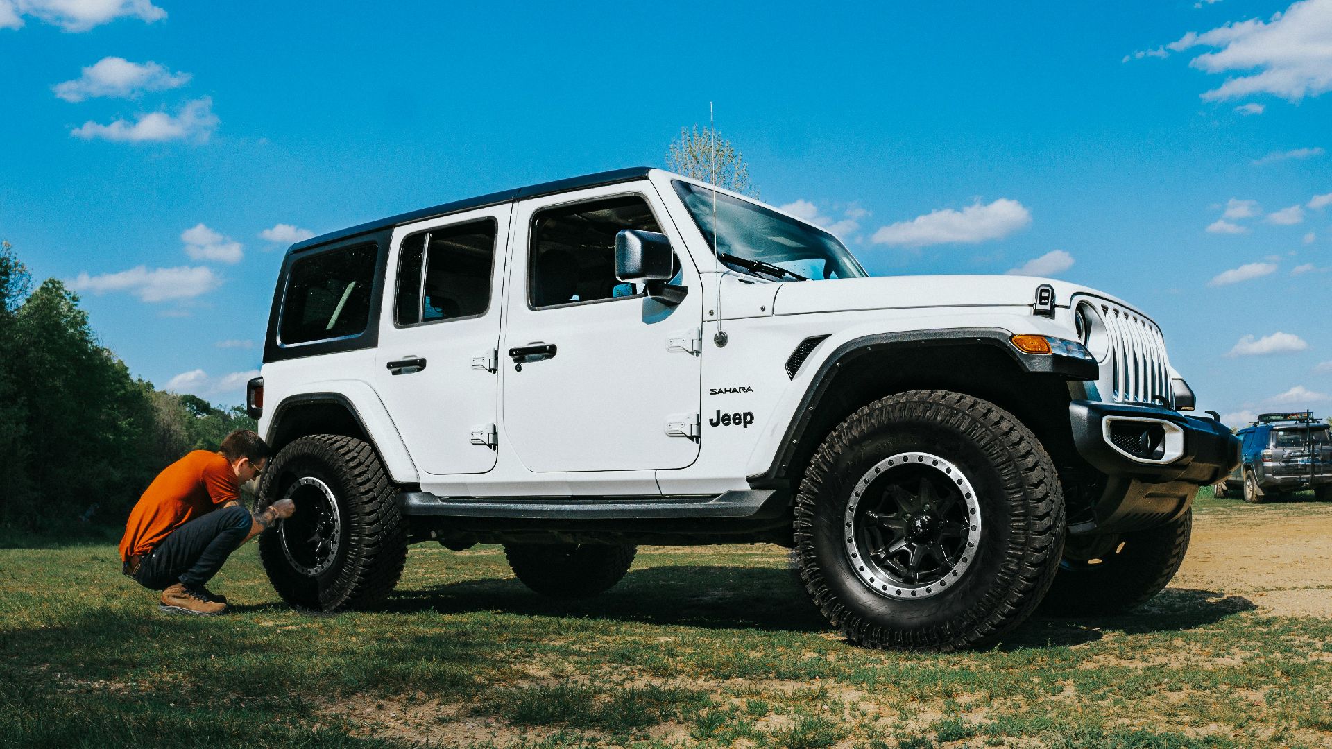 white suv on green grass field under blue sky during daytime
