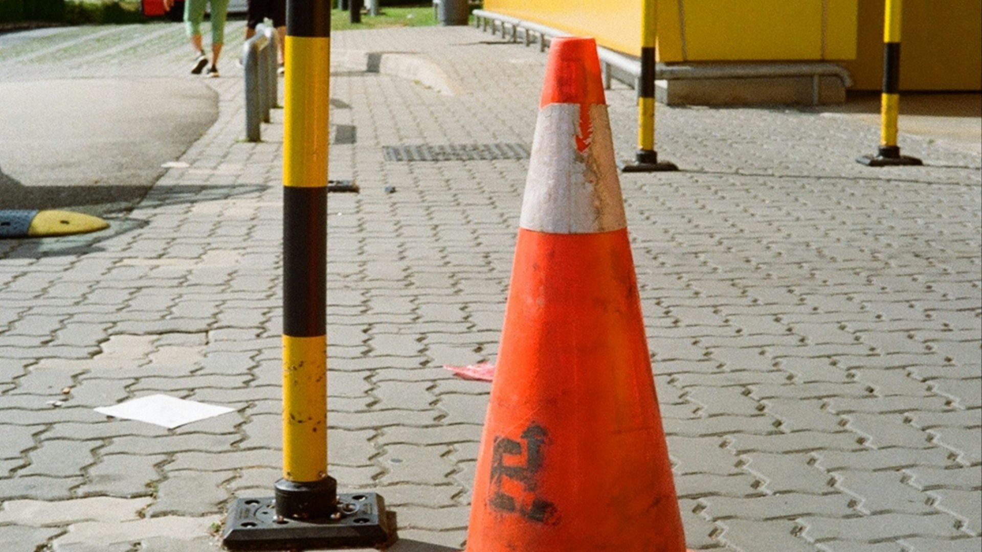 red and black traffic cone on gray concrete pavement