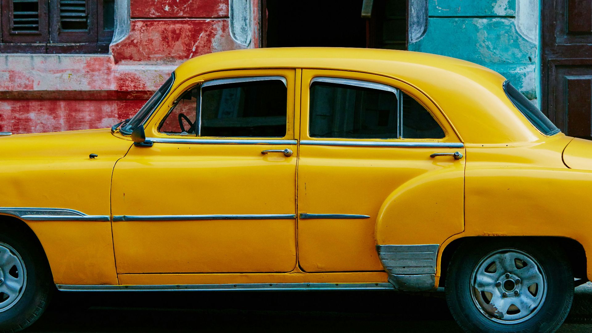 yellow sedan parked near red concrete building