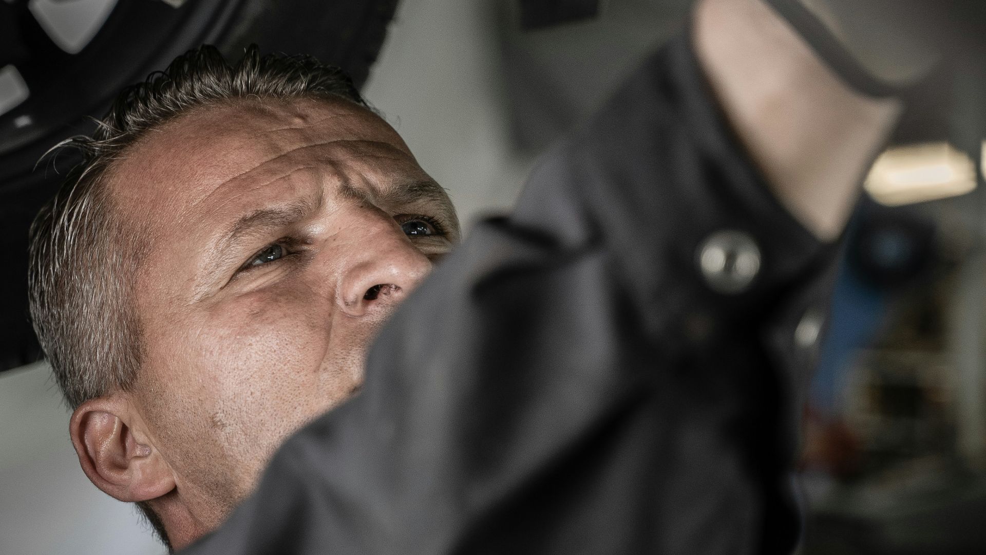 a man working on a car under a vehicle