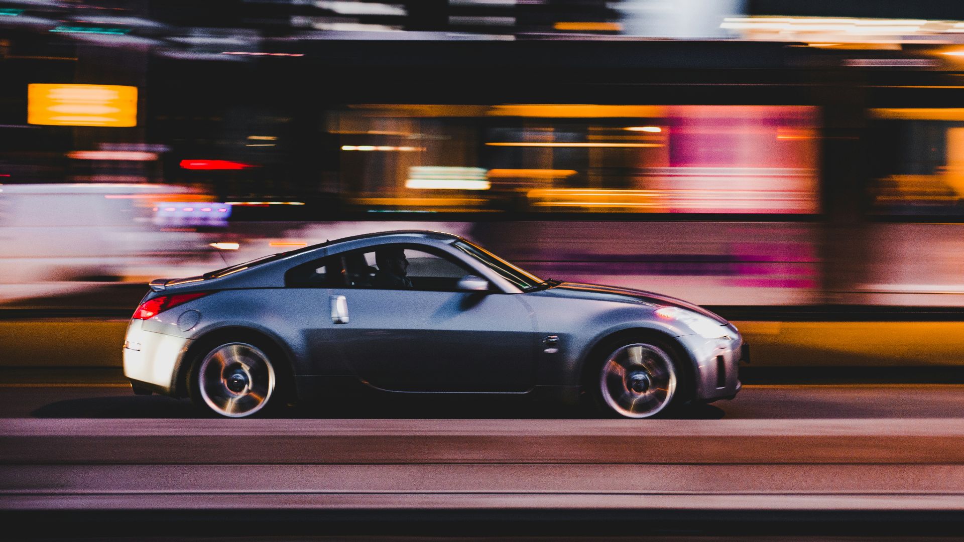 panning photography of gray coupe on road