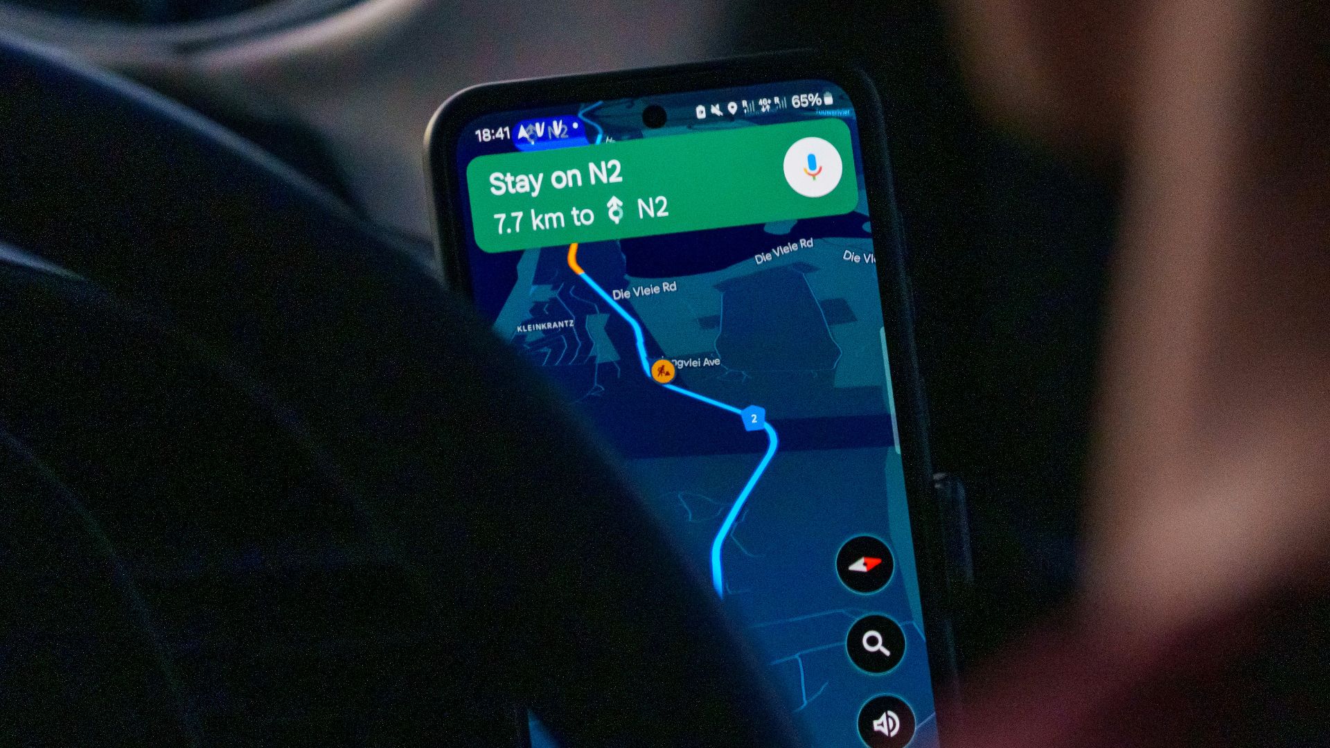 Person using navigation app on smartphone inside car.