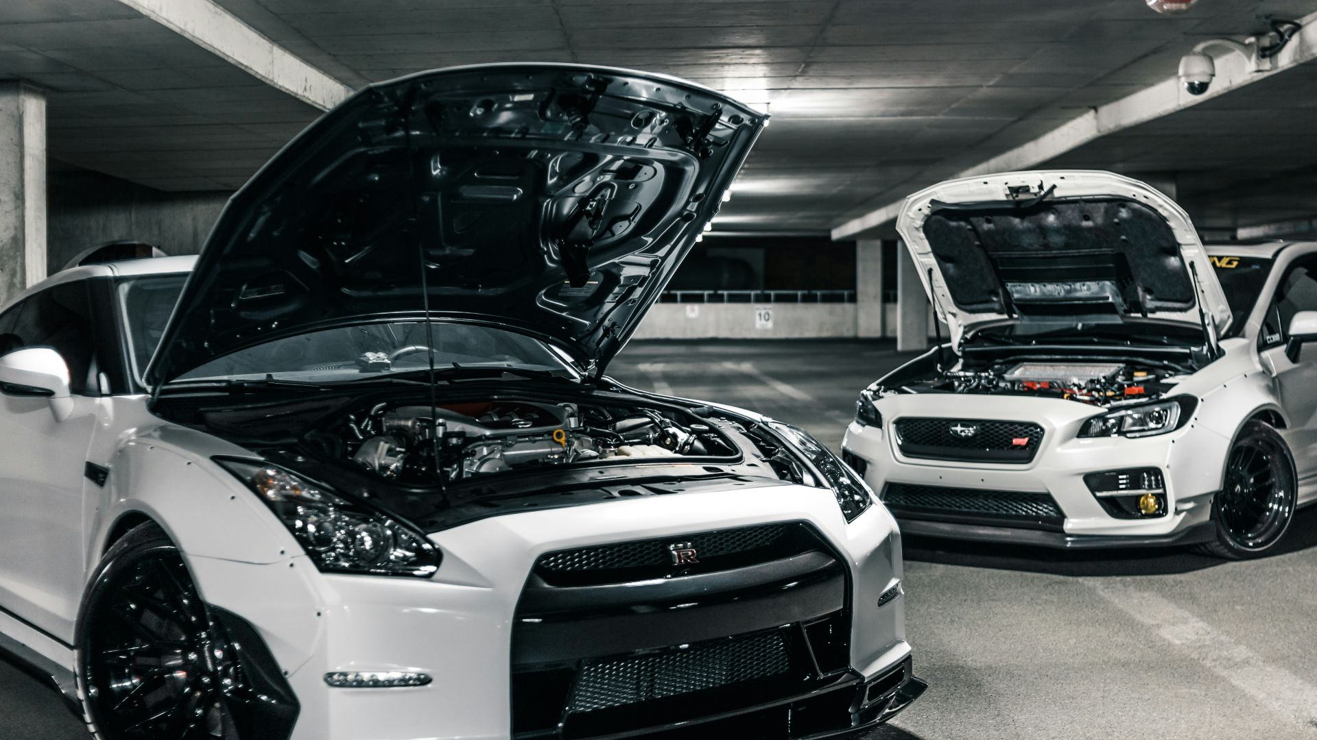 two white cars with open hoods