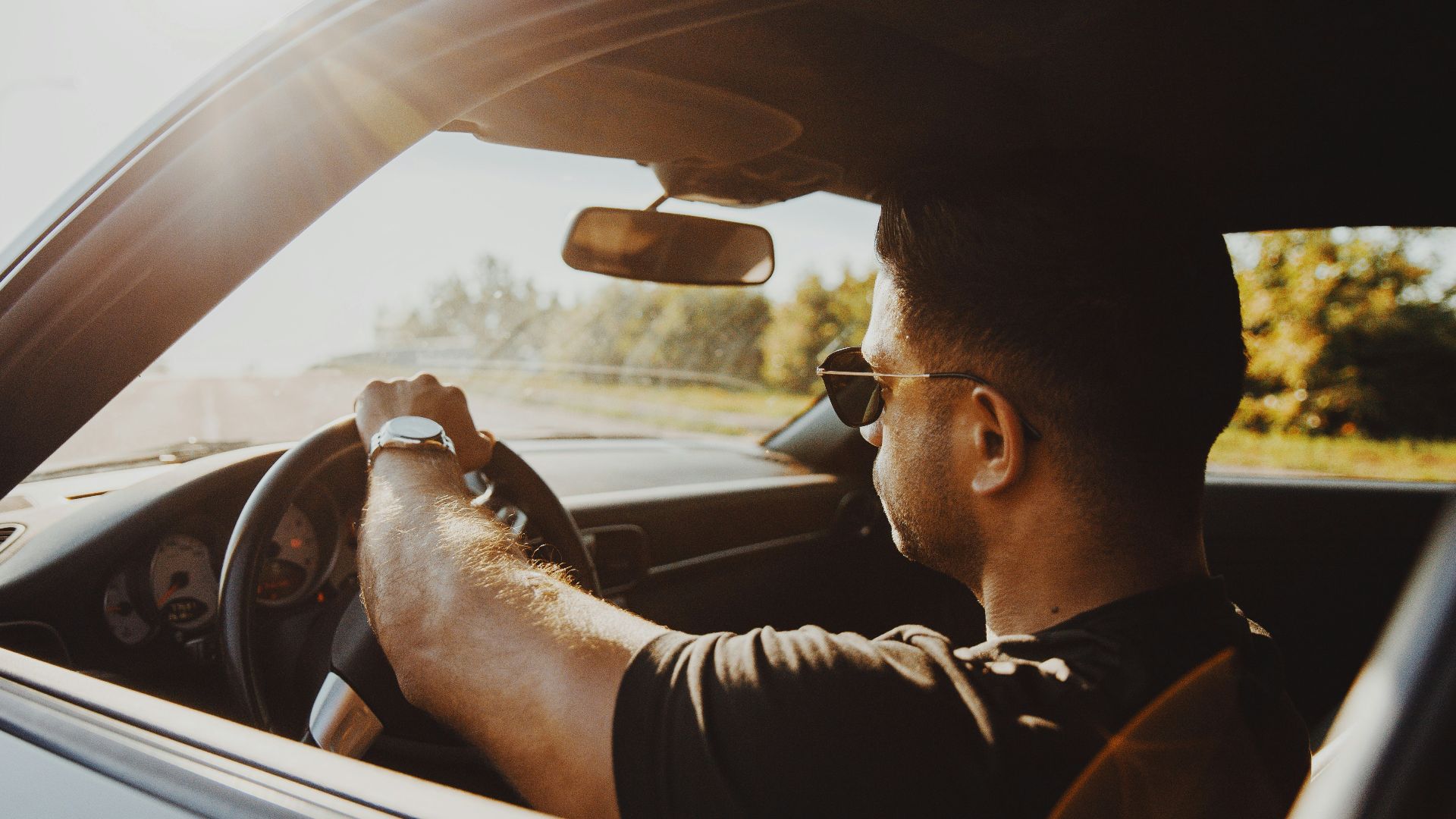 man in black jacket driving car during daytime
