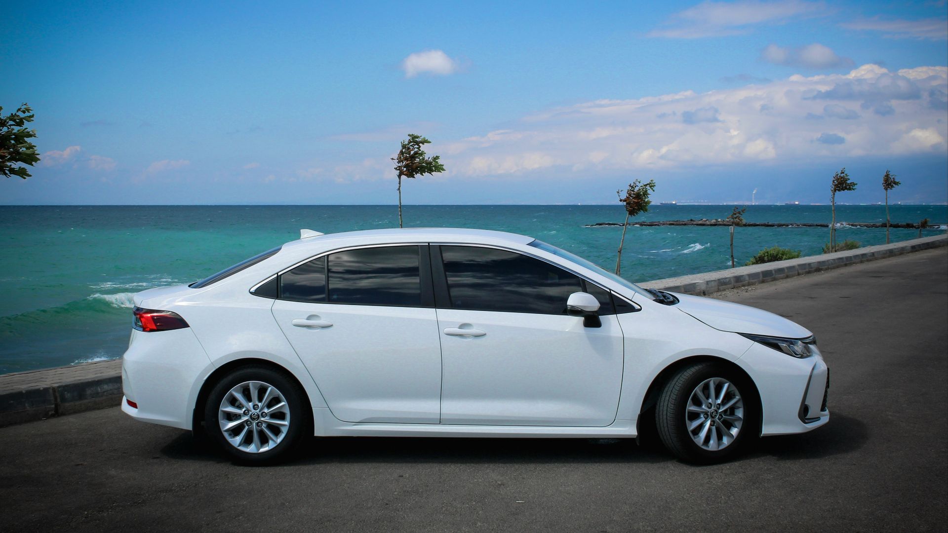 white sedan on gray asphalt road during daytime