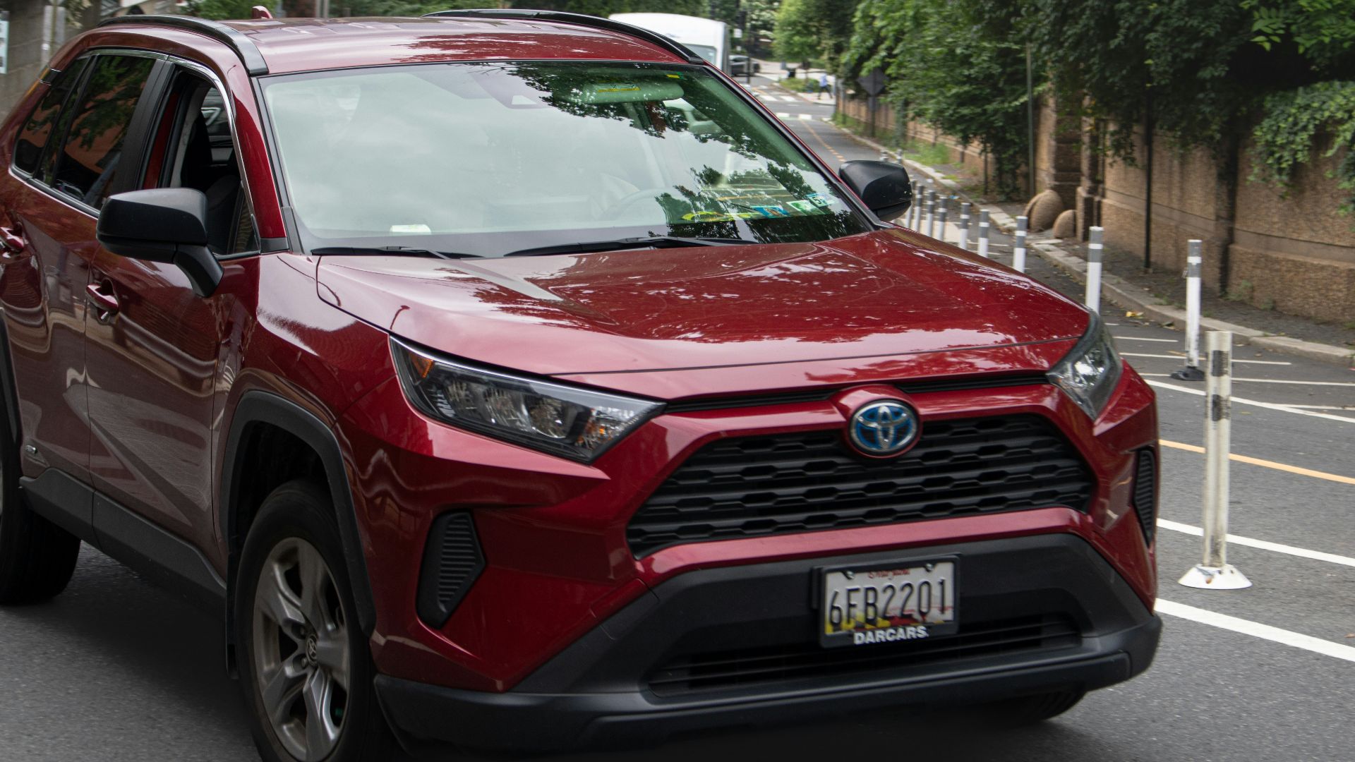 a red toyota rav driving down a street