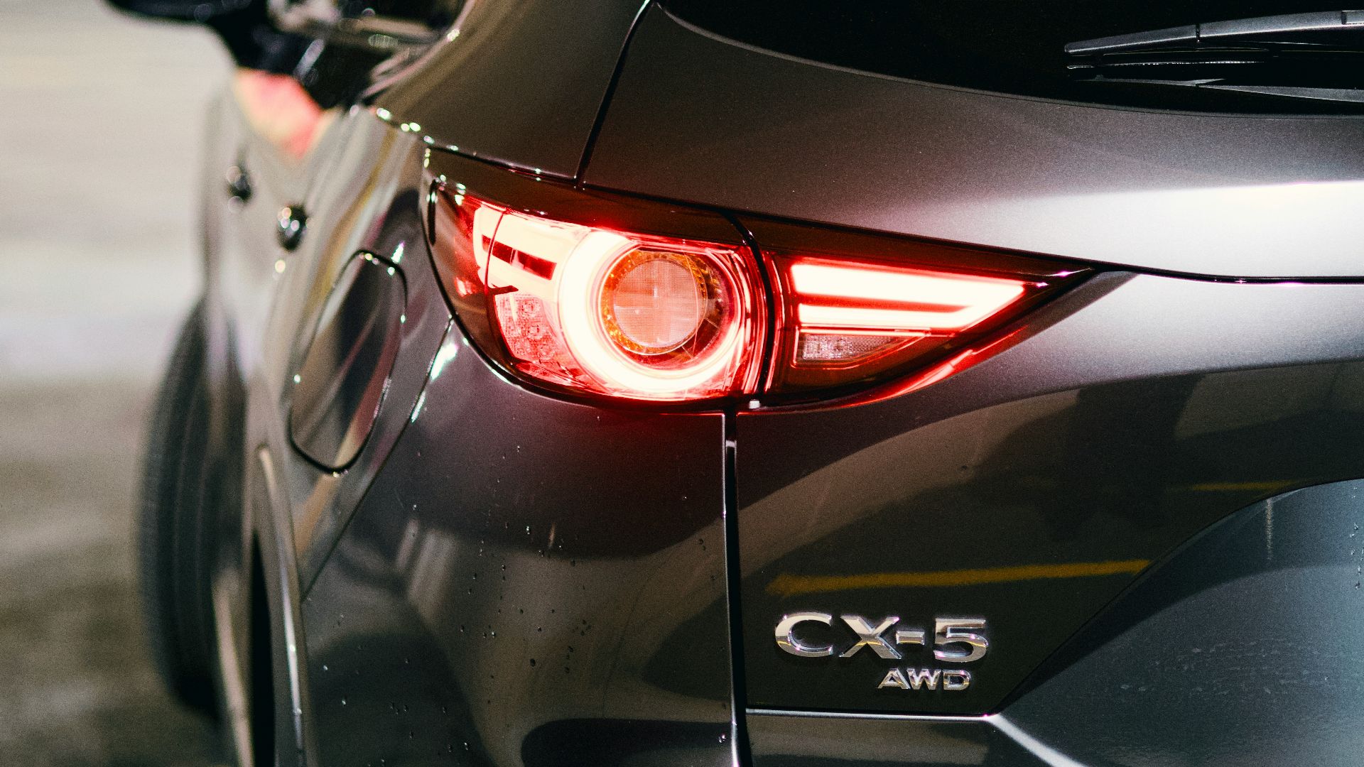 A gray mazda cx-5's rear light is illuminated.