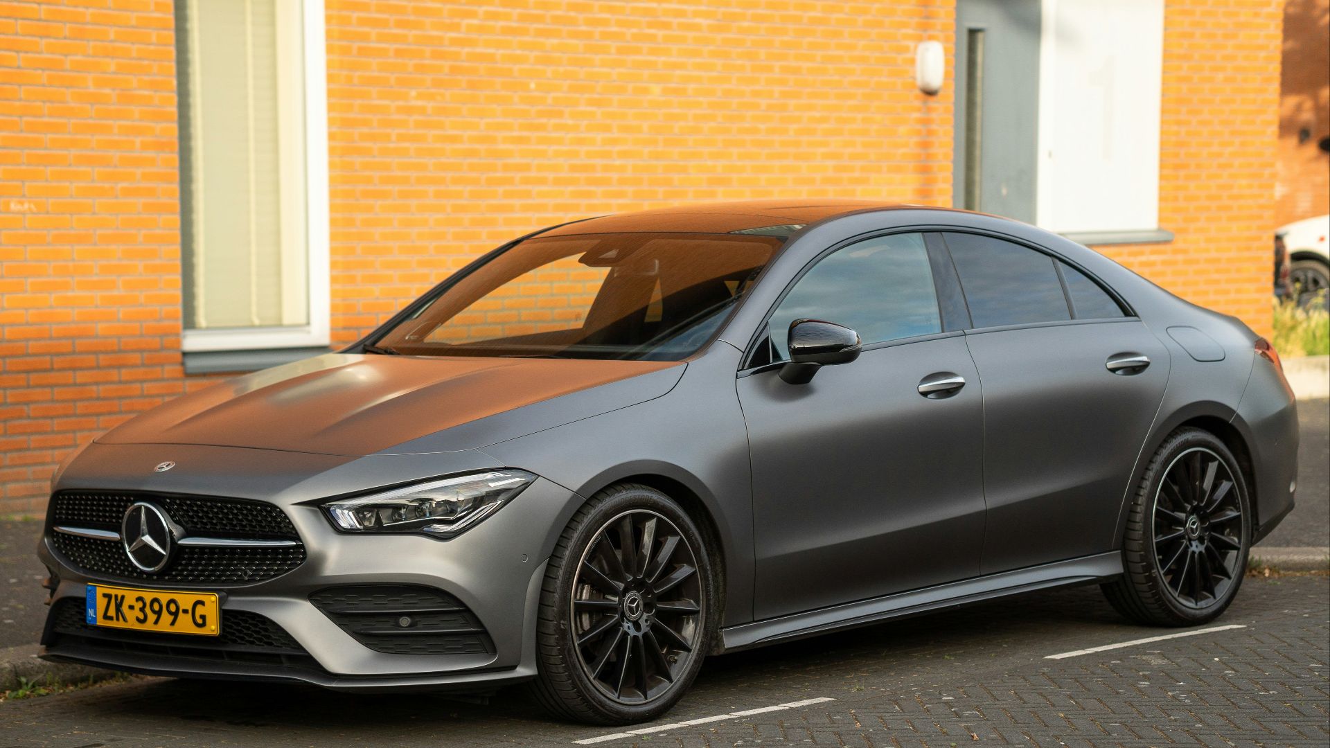 black mercedes benz c class parked beside brown brick building