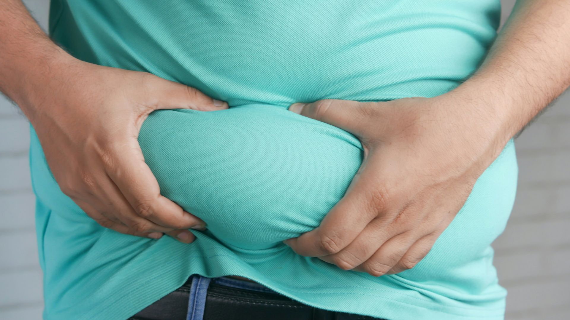 a man holding his stomach with his hands